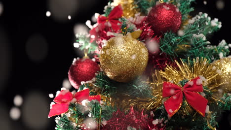 Christmas-decoration-tree-with-golden-ball-under-the-snow-falling-at-winter-night