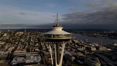 Panoramic-view-of-dense-urban-sprawl-while-orbiting-the-Seattle-Space-Needle,-aerial