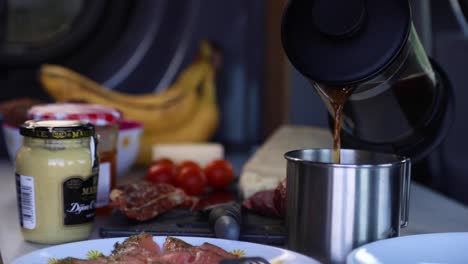 Pouring-Hot-Black-Coffee-Into-A-Stainless-Mug---Vanlife-Breakfast---close-up,-slow-motion