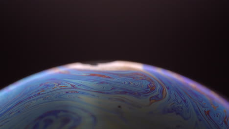 Blue-glowing-bubble-planet-in-black-background--close-up