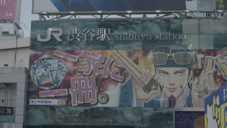 Jr-Line-Shibuya-Station-Schild-Und-Werbeanzeige-An-Der-Wand-Des-Gebäudes-Vom-Hachiko-platz-In-Tokio,-Japan