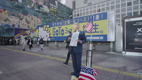 Hombre-Con-Máscara-De-Donald-Trump-En-La-Plaza-Hachiko-Cerca-De-La-Estación-De-Shibuya-En-Medio-Del-Brote-De-Covid-19-En-Tokio,-Japón