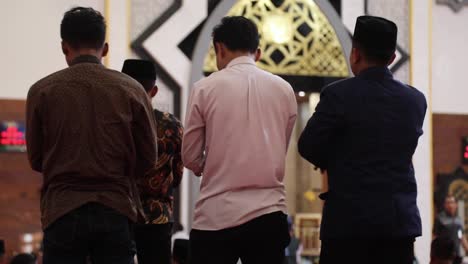 Grupo-De-Hombres-Musulmanes-Adorando-En-La-Mezquita-Del-Centro-Islámico-De-Pie---Lombok,-Indonesia---Tiro-Medio