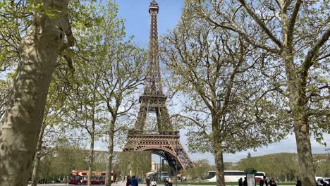 Ein-Blick-Auf-Den-Eiffelturm-Und-Die-Menschen-Und-Den-Verkehr-Durch-Die-Bäume-An-Einem-Schönen-Wintertag-In-Paris,-Frankreich