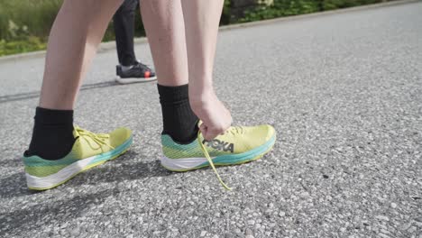 Corredora-Caucásica-Atando-Cordones-De-Zapatos-Preparándose-Para-Correr-Al-Aire-Libre---Luz-Solar-Brillante