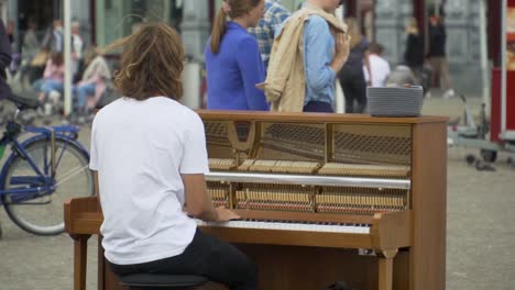Pianista-De-La-Calle-Entreteniendo-Y-Recaudando-Donaciones-De-Dinero-En-Amsterdam