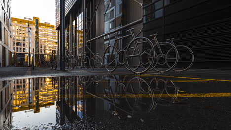 Bicycle-Racks-On-Wet-Alley-At-The-Barcode-Project-In-Oslo,-Norway-At-Daytime---low-level,-time-lapse