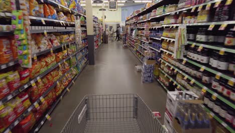 A-shopping-cart-moves-down-the-chip-aisle-in-a-grocery-store