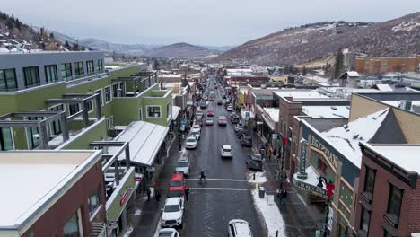 Main-Street-of-Tourist-Town-of-Park-City,-Utah-during-Snowy-Winter,-Aerial