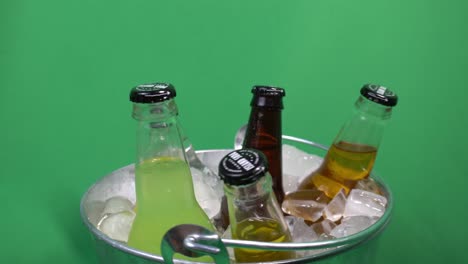 2-2-Island-Soda-drink-assortted-bottles-fruity-carbonated-drinks-rotating-in-an-ice-filled-drink-bucket-with-a-background-green-screen