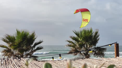 Palmen-Wehen-Im-Wind-Und-Kitesurfer-Haben-Spaß-An-Stürmischen-Tagen-Auf-Dem-Atlantik,-Portugal