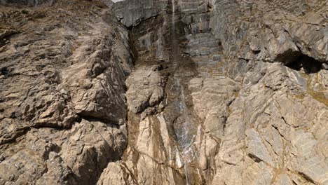 Nahe-Der-Felswand-Eines-Berges-Fliegen-Und-Dem-Flusslauf-Bergauf-Folgen