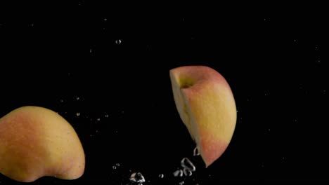 Apple-Falling-into-Water-Super-Slowmotion,-Black-Background,-lots-of-Air-Bubbles,-4k240fps