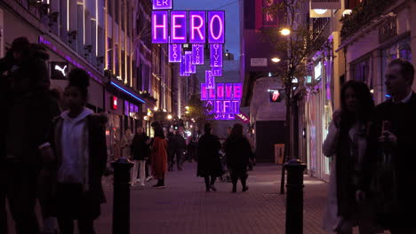 People-walk-past-closed-stores-underneath-Covid-pandemic-themed-Christmas-lights-on-Carnaby-Street-in-London’s-West-End