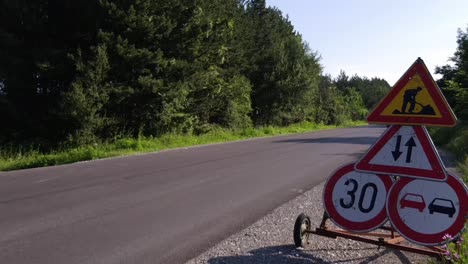 Señales-De-Tráfico-En-La-Carretera-Con-Vehículos-Que-Viajan-Durante-El-Verano-En-Omurtag,-Bulgaria