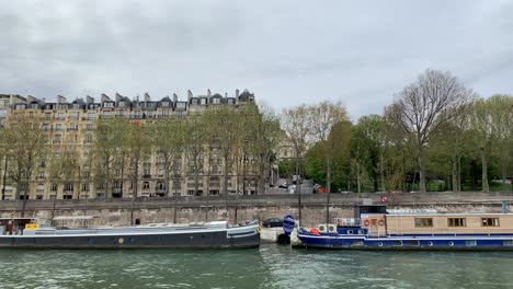 A-sideview-of-the-buildings-next-to-the-Seine-River-while-taking-a-sightseeing-boat-trip-in-Paris,-France