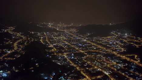 Aerial-cityscape-at-midnight-on-New-Years-Eve-above-Peru's-capital-city-Lima,-showing-city-lights-and-fireworks