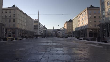 Time-Lapse-Sunrise-lights-over-Bergen-city-square,-busy-pedestrians-walking-on-winter-day