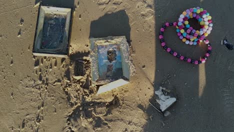 Sand-covered-religious-offerings-lay-on-the-beach-after-a-religious-festival-in-Uruguay-celebrates-Iemanjá,-goddess-of-the-sea-on-Carrasco-beach,-Uruguay