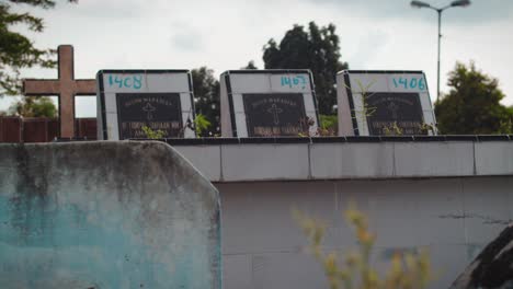 Cierre-De-Lápida-Con-Nombre-Y-Fecha-De-Nacimiento-Y-Muerte-Dentro-De-Un-Cementerio-Cristiano-En-La-Ciudad-De-Medan,-Gran-Cruz-En-El-Fondo