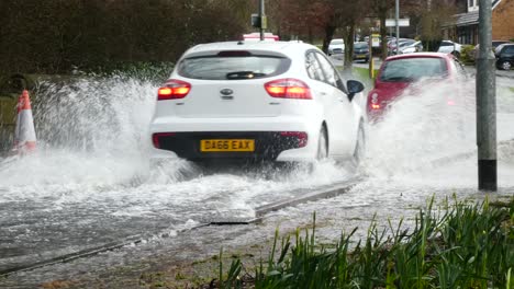 Storm-Christoph-car-driving-rainy-flooding-uk-village-road-splashing-street-cones