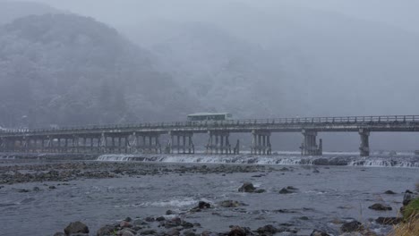 Schnee-Fällt-über-Die-Togetsukyo-Brücke-In-Arashiyama,-Während-Der-Bus-überquert