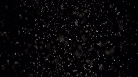 Snow-falling-on-night-black-background-at-slow-motion
