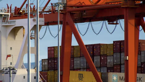 Cropped-View-Of-Gantry-Crane-With-Piles-Of-Cargo-Container-In-Background