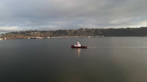 A-Crowley-tugboat-crosses-the-calm-waters-of-Commencement-Bay,-Tacoma,-aerial-orbit,-illustrative-editorial