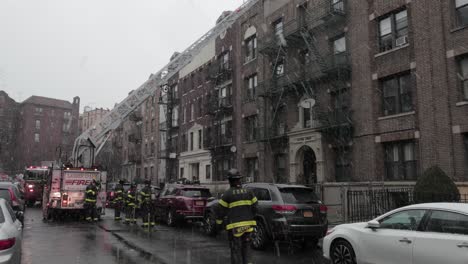Feuerwehrleute-Aus-New-York-City-Greifen-Mit-Einem-Leiterwagen-Auf-Das-Dach-Eines-Gebäudes-Zu---Breiter,-Langsamer-Schwenk