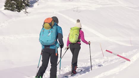 Couple-of-skiers-walking-in-snow-with-poles-in-slow-motion