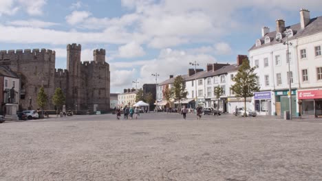 Caernarfon-town-centre-and-old-castle-with-people-and-car-passing