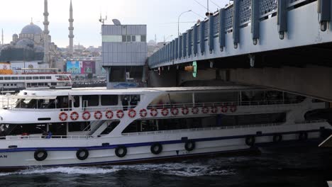 Transbordadores-Turyol-Navegando-En-El-Cuerno-De-Oro-Bajo-El-Puente-De-Galata-Con-Pescadores-Cerca-De-Yeni-Cami-En-Estambul,-Turquía