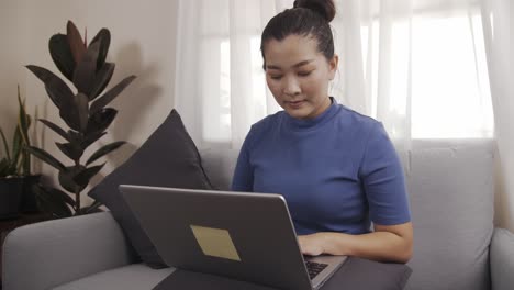 Asiatische-Geschäftsfrau-Nutzt-Gerne-Laptops,-Um-Online-Von-Zu-Hause-Aus-Zu-Arbeiten
