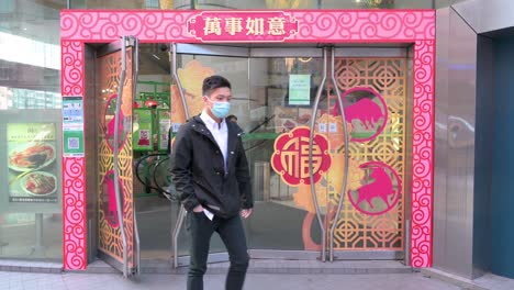 Shoppers-walk-in-and-out-through-doors-with-Chinese-Lunar-New-Year-decorative-theme-doors,-during-the-preparations-for-the-upcoming-Chinese-lunar-new-year-Ox-holidays