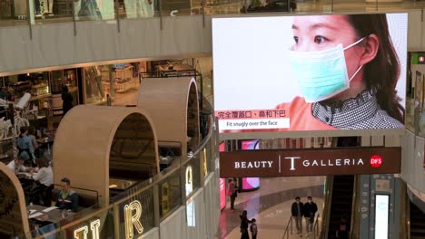 Una-Pantalla-De-Gran-Tamaño-En-Un-Centro-Comercial-Muestra-Un-Video-Para-Recordar-Al-Público-Sobre-La-Higiene-Y-El-Uso-De-Máscaras-Faciales-Como-Medida-Preventiva-Contra-La-Propagación-Del-Coronavirus-En-Hong-Kong