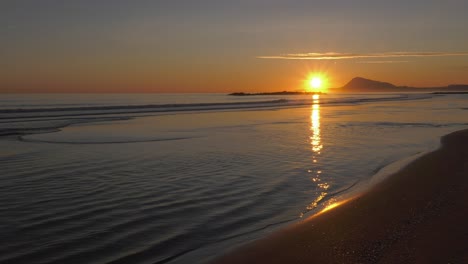 Sonnenaufgang-Am-Strand-Mit-Ruhigen-Wellen-Am-Sandufer,-Friedliche-Küste,-Mittelmeer,-Spanien