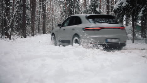 Graues-Porsche-Macan-Auto,-Das-Durch-Tiefen-Schnee-Im-Wald-Fährt