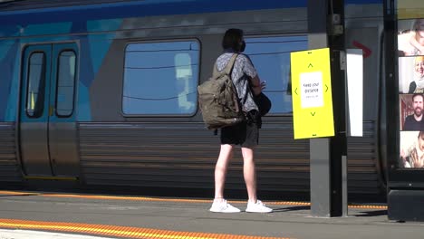 Man-wearing-a-mask-waits-on-an-empty-train-platform-during-the-coronavirus-outbreak-in-Australia