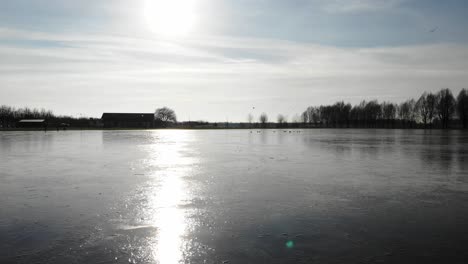 Helles-Sonnenlicht-Am-Morgen-Spiegelt-Sich-Auf-Der-Oberfläche-Des-Zugefrorenen-Flusses-Im-Sandelingen-Park-In-Hendrik-ido-ambacht,-Niederlande