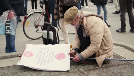 älterer-Mann,-Der-Während-Einer-Demonstration-Gegen-Die-Regierung-Die-Protestplakatwand-Auf-Dem-Mailänder-Platz-Vorbereitet