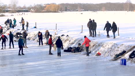 Winter-time-warp-panning-time-lapse-with-people-on-the-side-of-the-frozen-river-Berkel-preparing-to-ice-skate-panning-to-show-the-wider-snow-landscape-showing-the-leisure-activities