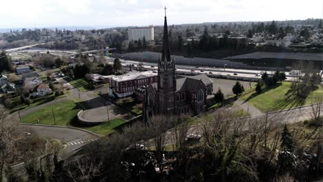 Iglesia-Católica-Del-Santo-Rosario,-Centro-De-Tacoma-En-El-Fondo,-órbita-Aérea