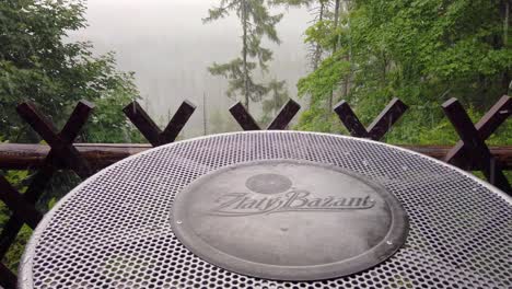 Granizo-Cayendo-Sobre-Una-Mesa-De-Cerveza-En-Un-Bar-De-Montaña-Con-Fondo-Forestal