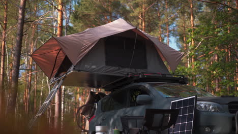 Sports-utility-vehicle-parked-in-the-forest-with-a-roof-top-tent