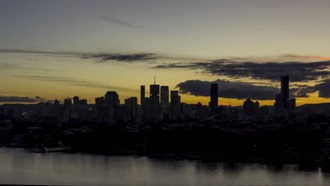 Brisbane-City-Sunset-Timelapse,-Eine-Wunderschöne-Orange-Leuchtende-Sonne,-Die-Hinter-Stadtgebäuden-Untergeht