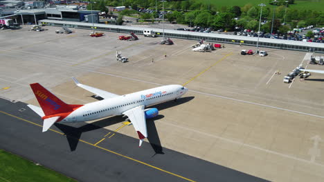 Tracking-shot-of-a-Sunwing-airplane-taxiing-to-its-arrival-terminal-gate