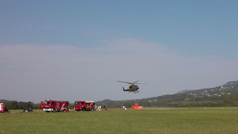 Helicopter-filling-bucket-with-water-to-fight-wild-bush-fire,-aerial-firefighting,-military-assisting-firefighters-in-Slovenia
