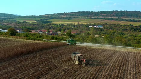 Establecimiento-De-Una-Toma-Aérea-Con-Drones-De-Un-Tractor-Combinado-John-Deere-Cosechando-Semillas-De-Girasol-Durante-La-Noche-De-Verano-En-El-Campo-Rural-Búlgaro