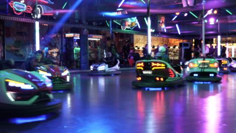 Close-up-shot-of-people-driving-illuminated-bumper-cars-at-night,static